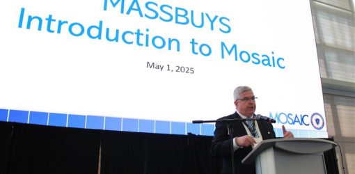 Comptroller McNamara at a podium in front of a large screen with a title slide that says MASSBUYS introduction to Mosaic