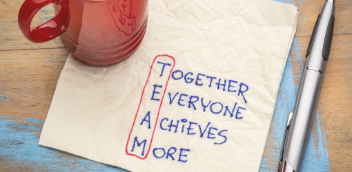 Mug on napkin with Together Everyone Achieves More with letters TEAM circled
