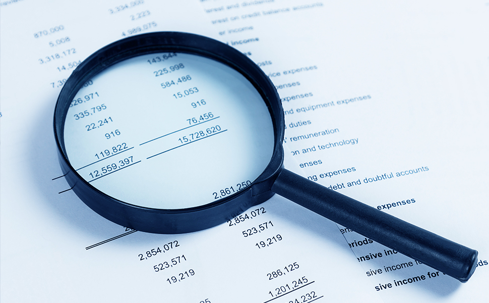 A magnifying glass enlarging financial statements